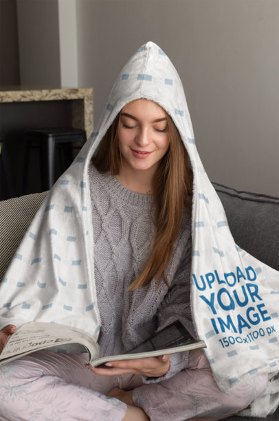 Hooded Fleece Blanket Mockup Featuring a Woman Reading a Magazine on Her Bed