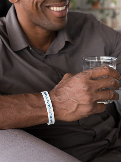 Silicone Wristband Mockup Featuring a Man Holding a Glass of Water