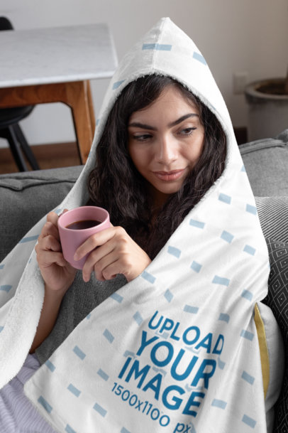 Mockup of a Young Woman Covered with a Hooded Fleece Blanket 