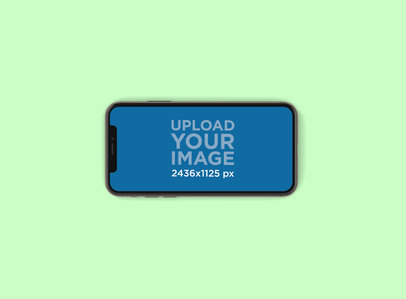 Mockup of an iPhone 11 Pro in Landscape Position Lying in a Color-Custom Backdrop