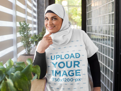 T-Shirt Mockup of a Woman Wearing a Hijab in a Hallway