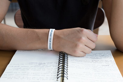 Silicone Wristband Mockup of a Man Looking at His Notes