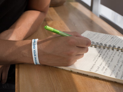 Silicone Wristband Mockup of a Man Writing down Notes