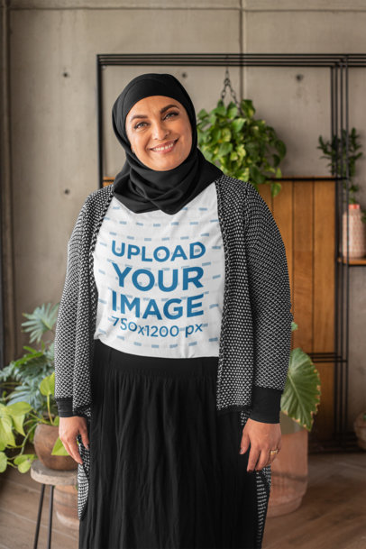 T-Shirt Mockup of a Woman Wearing a Hijab in a Room with Plants