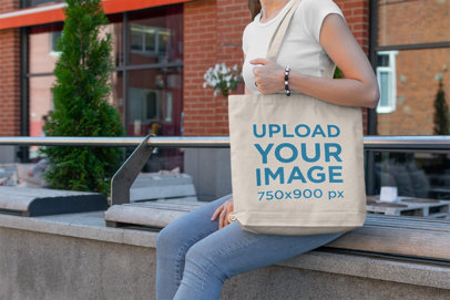 Tote Bag Mockup of a Woman Sitting on an Urban Bench 191-el