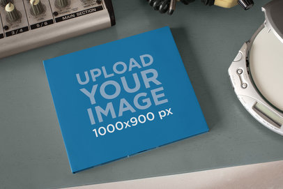 Mockup of a Digipak on a Desktop Next to a CD Player 28347