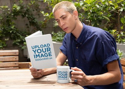 Mockup of a Man Reading a Book and Holding an 11 oz Coffee Mug Outside