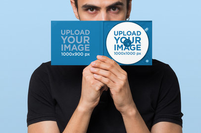 Mockup of a Man Hiding His Face Behind a Digipak with a CD