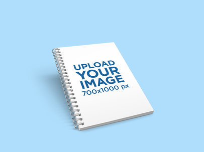 Mockup of an A5 Spiral Notebook Floating over a Minimalist Setting 308-el