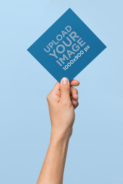 Mockup Featuring a Hand Holding a Digipak in the Air 