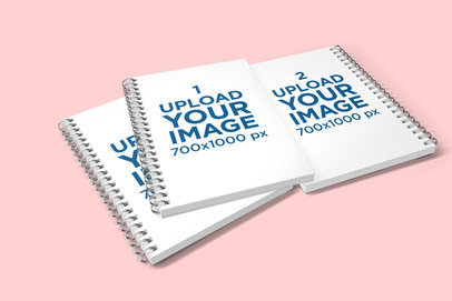 Mockup of Three Piled A5 Spiral Notebooks in a Customizable Backdrop