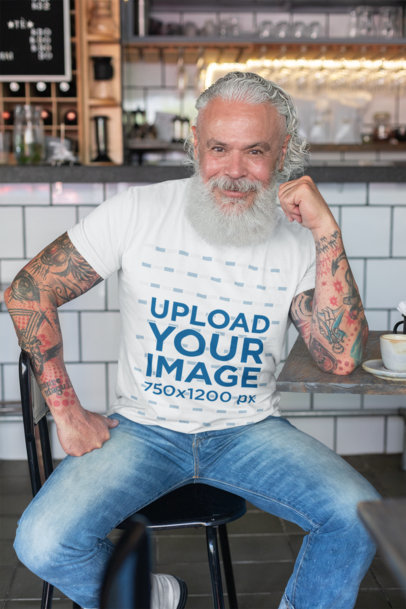 T-Shirt Mockup of a Tattooed Man at a Cafe 
