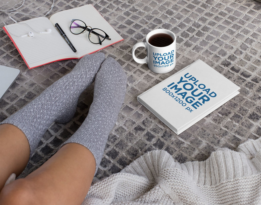 Mockup of an 11 oz Mug and a Book Placed on the Floor 