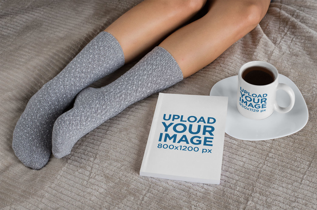 Mockup of an 11 oz Mug and a Book on a Bed 