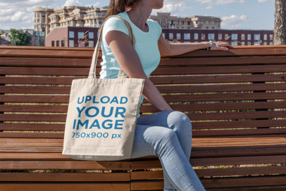 Tote Bag Mockup of a Young Woman Sitting on a Park Bench 
