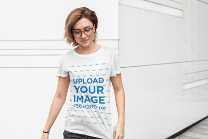 Tee Mockup Featuring a Short-Haired Woman with Glasses Against a White Wall