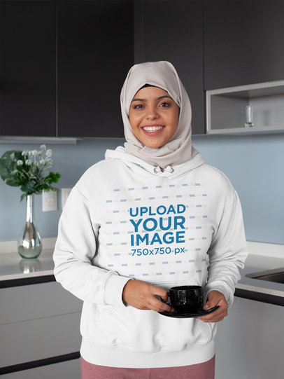 Mockup of a Woman with a Hijab Wearing a Hoodie in the Kitchen