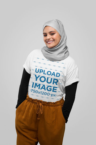 T-Shirt Mockup Featuring a Joyful Woman Wearing a Hijab at a Studio 