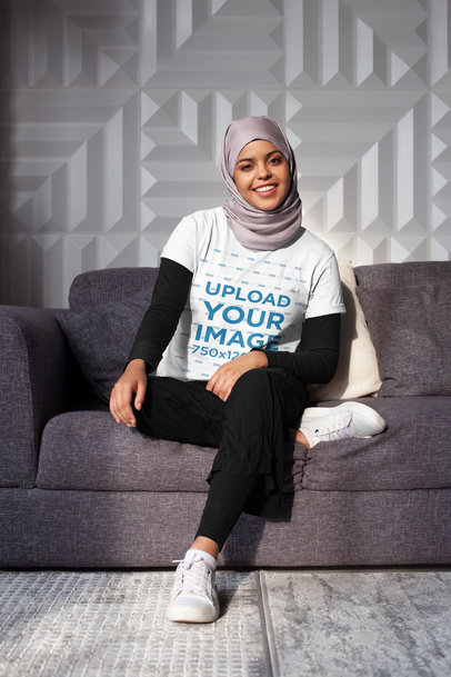 T-Shirt Mockup of a Woman with a Hijab Sitting with One Leg Crossed 