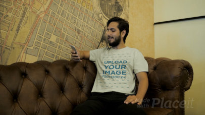 T-Shirt Video of a Man Sitting on a Vintage Couch Checking His Phone 28924