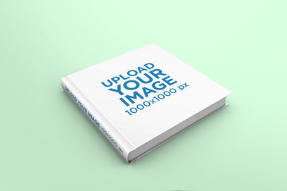 Mockup Featuring a Hardcover Square Book Lying on a Solid Color Surface 296-el