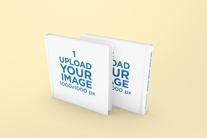 Mockup Featuring Two Hardcover Square Books Standing Against a Solid Color Backdrop 