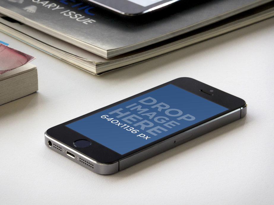Mockup of an iPhone 5 Placed Next to Some Books