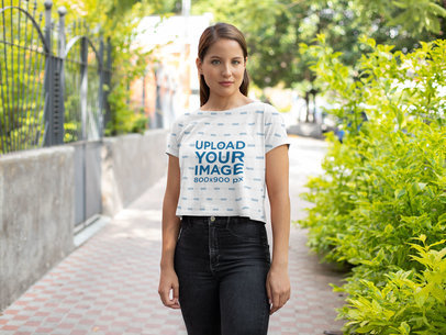 Mockup of a Woman Wearing a Sublimated Crop Top on a Street 
