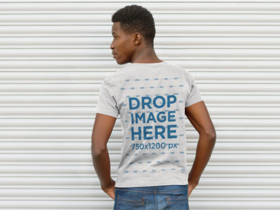 Back Mockup of a Guy Wearing a T-Shirt Facing a Steel Rollup Door a9281b