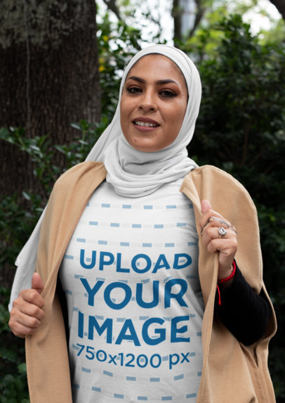 T-Shirt Mockup of a Smiling Woman Wearing a Hijab by a Tree