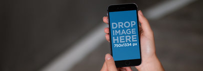 iPhone Mockup Being Held in Front of a Black Background