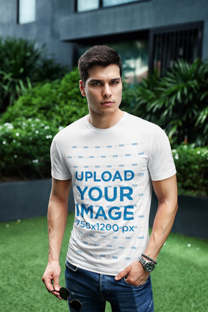 T-Shirt Mockup Featuring a Stylish Man Posing at a City Garden 