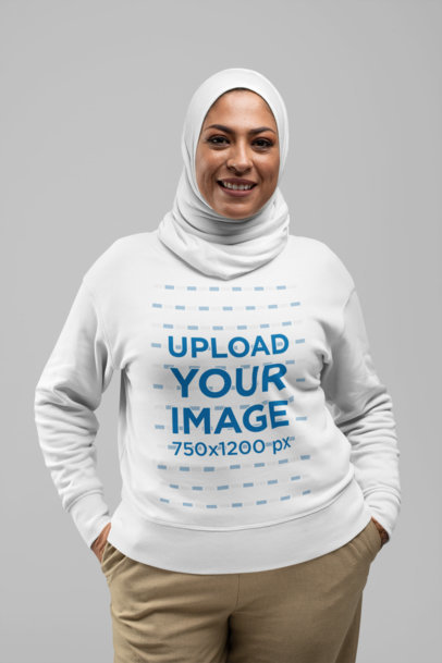 Crewneck Sweatshirt Mockup of a Smiling Woman with a Hijab Standing Against a Plain Backdrop 