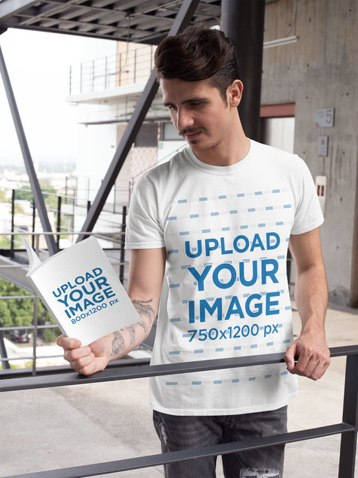 Book Mockup of a Man Wearing a T-Shirt and Reading Outside