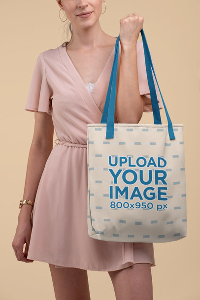 Mockup of a Woman Holding a Tote Bag with Customizable Strap at a Studio