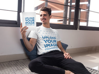 T-Shirt Mockup Featuring a Man Sitting on the Floor and Reading a Book