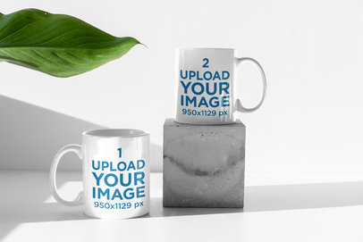 Mockup of Two 11 oz Coffee Mugs by an Indoor Plant
