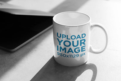 11 oz Coffe Mug Mockup Beside a Semi-Open Laptop 403-el