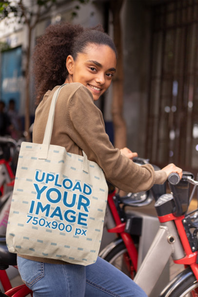 Mockup of a Customizable Strap Tote Bag Featuring a Woman with a Bike 