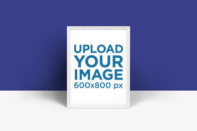 Mockup of a Poster Frame Leaning Against a Blue Wall