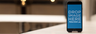 Mockup Template of an iPhone Standing on a Restaurant Table