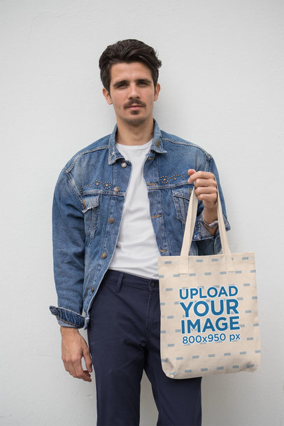 Mockup of a Trendy Man Holding a Tote Bag 