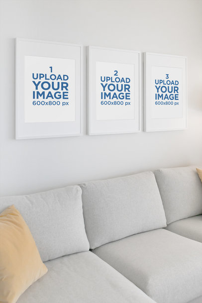 Mockup Featuring Three Poster Frames Hanging in a Living Room 