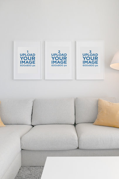 Mockup Featuring Three Poster Frames Hanging over a Couch 