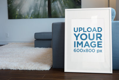 Mockup of a Poster Frame Leaning Against a Modern Couch 