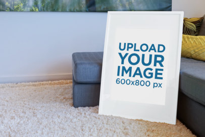 Mockup of a Poster Frame Leaning on a Couch at a Living Room Floor