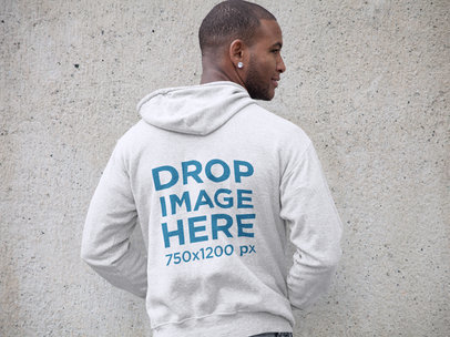Mockup of a Man Wearing a Pullover Hoodie Facing a Wall