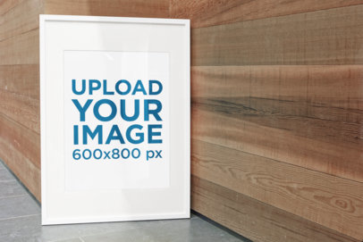Poster Frame Mockup Featuring a Wooden Wall
