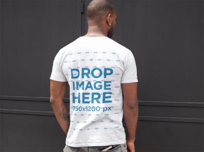 Back Mockup of a Handsome Man Wearing a T-Shirt Facing a Black Door