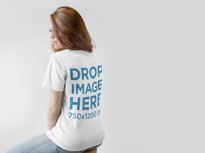 Back of a Redhaired Woman Wearing a T-Shirt Mockup Facing a White Wall